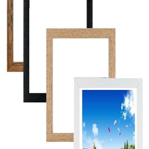 May include: Three picture frames in different colours and styles. The frames are nested inside each other, with the largest frame being a rustic brown wood, the middle frame being black, and the smallest frame being a light wood. The smallest frame is showing a picture of a book lying open in a field with flowers and a blue sky.