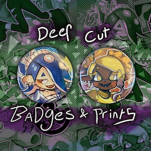 May include: Two round, colorful buttons featuring cartoon characters from the video game Splatoon. The buttons are labeled "Deep Cut" and feature a blue and purple character with a yellow and orange character.