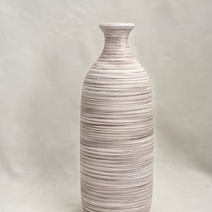 May include: A white and brown ceramic vase with a striped pattern. The vase has a narrow neck and a wide base.