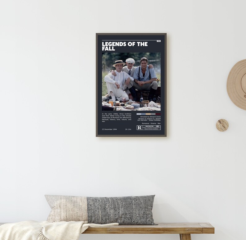 Op de afbeelding: Een zwart-wit poster voor de film "Legends of the Fall". De poster toont een foto van drie mannen die op een picknickdeken in een bosrijke omgeving zitten. De poster bevat ook de titel van de film, de releasedatum en de leeftijdsclassificatie.