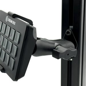 Könnte beinhalten: Ein schwarzes Stream Deck Bedienfeld mit fünfzehn quadratischen Tasten, montiert an einem verstellbaren schwarzen Gelenkarm, der an einer vertikalen Metallschiene befestigt ist. Das Gerät hat eine matte Oberfläche und das weiße Stream Deck Logo.