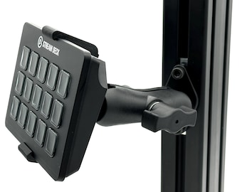 Könnte beinhalten: Ein schwarzes Stream Deck Bedienfeld mit fünfzehn quadratischen Tasten, montiert an einem verstellbaren schwarzen Gelenkarm, der an einer vertikalen Metallschiene befestigt ist. Das Gerät trägt den weißen Schriftzug STREAM DECK am oberen Rand.