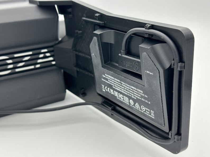 May include: Black VR headset with a black cable attached to the side. The headset has a white logo that says "Oculus" and a label with the text "1 USB Type-C".