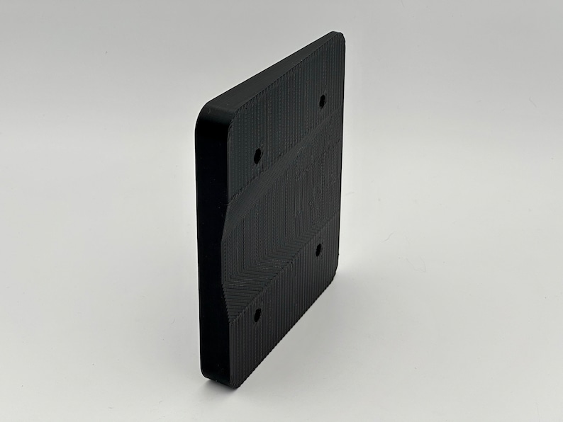 May include: Black plastic wall mount with four screw holes and a curved edge.