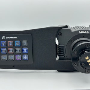 May include: A black Stream Deck mini controller mounted to a black Moza camera gimbal. The Stream Deck has 15 buttons with various colored icons. The gimbal has a black knob with a gold logo.