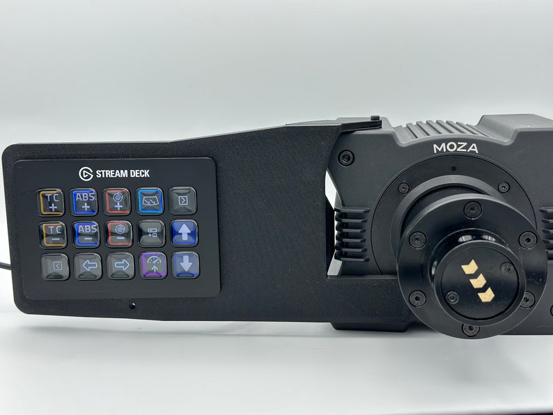 May include: A black Stream Deck mini controller mounted to a black Moza camera gimbal. The Stream Deck has 15 buttons with various colored icons. The gimbal has a black knob with a gold logo.