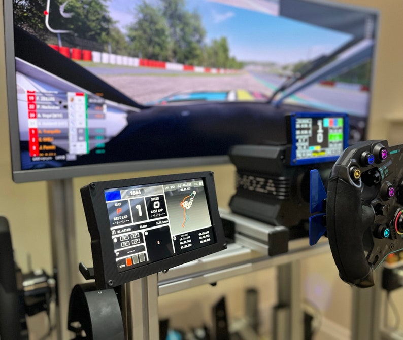 May include: A black racing simulator setup with a large screen displaying a racing game, a steering wheel, and a dashboard with a digital display showing the lap time and speed. The dashboard also shows the gap between the driver and the car in front.