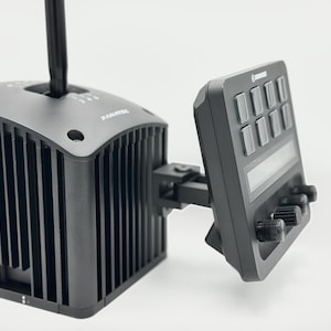 May include: A black Fanatec sim racing shifter with a vertical gear stick and a ribbed housing, attached to a black control panel featuring eight rectangular buttons, a horizontal display screen, and three circular adjustment knobs on the front.