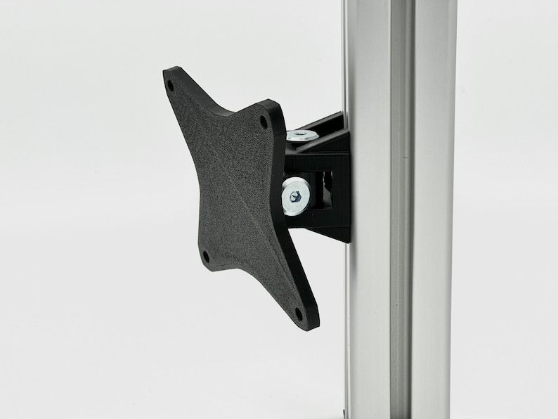K&ouml;nnte beinhalten: Eine schwarze Monitorhalterung aus Kunststoff mit einem Schwenkarm, befestigt an einer silbernen Aluminiumstange.
