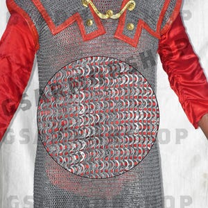 May include: A silver chainmail shirt with red trim. The chainmail is made of small, interlocking metal rings.