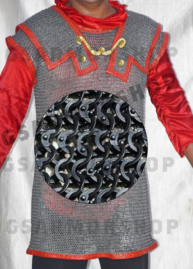 May include: A silver chainmail shirt with red trim. The chainmail is made of interlocking metal rings. The shirt is worn by a person with a red shirt underneath.