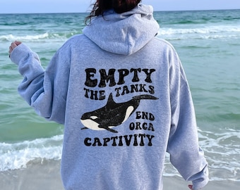 May include: A gray hoodie with a black graphic of an orca whale and the text "Empty the Tanks End Orca Captivity".