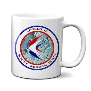 Peut inclure: Mug en céramique blanche avec un patch de mission Apollo 15 bleu, rouge et blanc. Le patch représente un croissant de lune avec un oiseau stylisé en vol. Le texte "APOLLO 15" est en haut du patch, et les noms "SCOTT WORDEN IRWIN" sont autour du bas du patch.