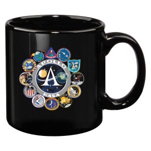 May include: Black ceramic coffee mug with a graphic of the NASA Apollo program logo surrounded by the logos of each Apollo mission.
