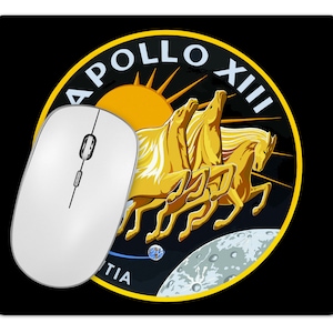 May include: A black mousepad with a yellow and white Apollo XIII mission patch. The patch features three horses running, a sun, and a crescent moon.