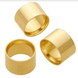 May include: Three gold-colored metal rings, each with a smooth, polished finish. The rings are stacked on top of each other, with the largest ring at the bottom and the smallest ring at the top.