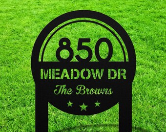 Puede incluir: Señal de jardín de metal negro con forma redondeada y fondo blanco. La señal presenta el número 850, el texto "Meadow Dr" y el texto "The Browns" con tres estrellas debajo.