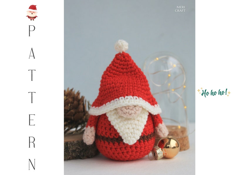 May include: A crocheted Santa Claus gnome with a red hat, white beard, and brown belt. The gnome is sitting on a wooden surface with a gold bauble nearby. The text "Ho ho ho!" is in the background.