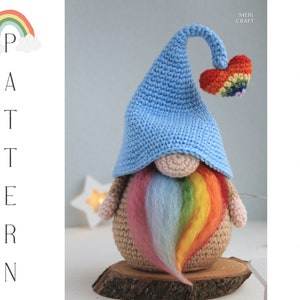 May include: A crocheted gnome with a rainbow beard and a blue hat with a rainbow heart on top. The gnome is sitting on a wooden slice. The text "PATTERN" is written vertically on the left side of the image.