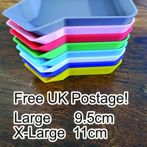 以下が含まれることがあります： グレー、ピンク、赤、緑、青、白、黄色のカラフルな長方形のトレイのスタック。トレイは、わずかに隆起したエッジと小さなノッチを備えたユニークな形状をしています。トレイのサイズは約9.5cmから11cmです。