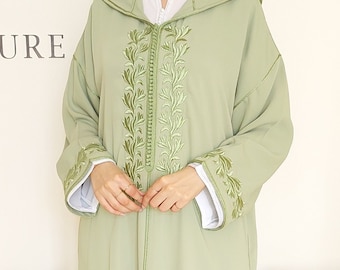 Op de afbeelding: Een saliegroene gekapte robe met ingewikkelde groene borduursels met een bloemenpatroon. De robe heeft een lange, vloeiende silhouet en een ritssluiting.