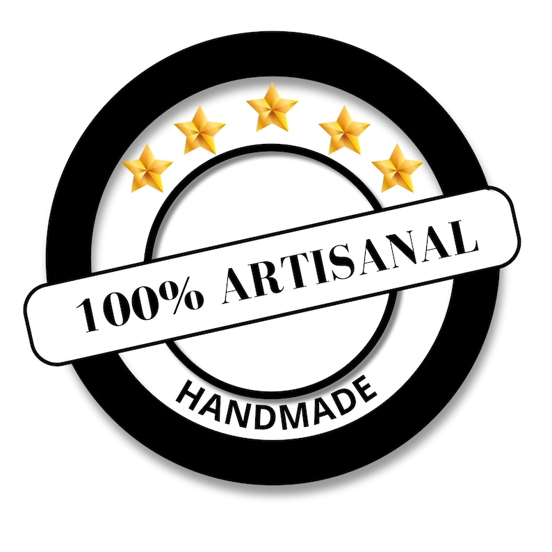 May include: A circular black and white badge with the words "100% ARTISANAL HANDMADE" in black text. Five gold stars are arranged in an arc above the text. The badge is on a white background.