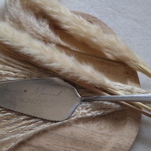 Personalisierter Tortenheber in Silber oder Gold – eine edle und praktische Ergänzung für Hochzeiten, Geburtstage oder Jubiläen. Mit individueller Gravur wird der Tortenheber zu einem besonderen Highlight auf jeder Feier und einem einzigartigen Erinnerungsstück. Ideal als Geschenk zur Hochzeit, Verlobung oder als liebevolles Mitbringsel für Backliebhaber.
