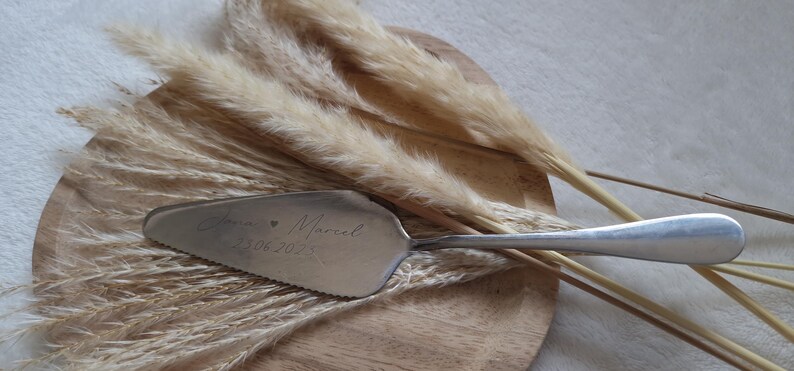 Personalisierter Tortenheber in Silber oder Gold – eine edle und praktische Ergänzung für Hochzeiten, Geburtstage oder Jubiläen. Mit individueller Gravur wird der Tortenheber zu einem besonderen Highlight auf jeder Feier und einem einzigartigen Erinnerungsstück. Ideal als Geschenk zur Hochzeit, Verlobung oder als liebevolles Mitbringsel für Backliebhaber.