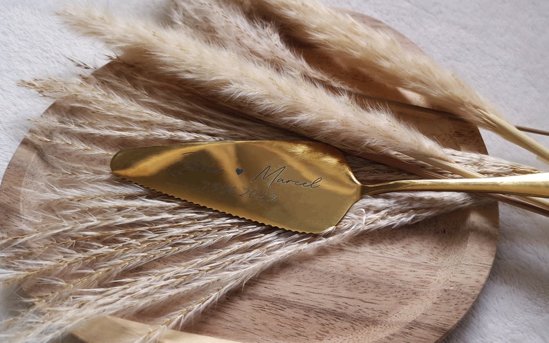 Personalisierter Tortenheber in Silber oder Gold – eine edle und praktische Ergänzung für Hochzeiten, Geburtstage oder Jubiläen. Mit individueller Gravur wird der Tortenheber zu einem besonderen Highlight auf jeder Feier und einem einzigartigen Erinnerungsstück. Ideal als Geschenk zur Hochzeit, Verlobung oder als liebevolles Mitbringsel für Backliebhaber.