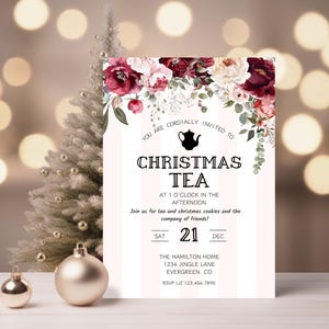 May include: A Christmas tea party invitation with a floral design in shades of burgundy and pink. The invitation features a teapot icon and the text "Christmas Tea" in a bold font. The date of the party is listed as Saturday, December 21st. The invitation also includes the address and RSVP information.