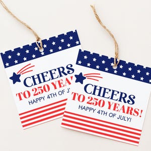 May include: Two square gift tags with a patriotic theme. Each tag has a blue border with white stars, red and white stripes, and the text "CHEERS TO 250 YEARS! HAPPY 4TH OF JULY!" in red and blue. They are tied with twine.