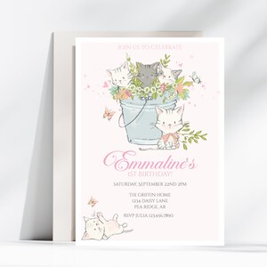 May include: A pink and white invitation with a cartoon illustration of four kittens in a blue bucket with flowers. The text reads "Join us to celebrate Emmaline's 1st Birthday! Saturday, September 22nd 2PM The Griffin Home 1234 Daisy Lane Pea Ridge, AR RSVP Julia 1234567890"