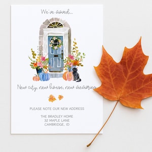 May include: A moving announcement card with a watercolour illustration of a blue door, pumpkins, and a black cat. The text reads "We've moved... New city, new house, new memories." An orange maple leaf is on the side.