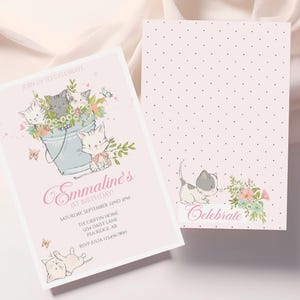 May include: Pink and white invitation with a floral design and a group of kittens in a bucket. The text reads "Join us to celebrate Emmaline's 1st Birthday" and includes the date, time, location, and RSVP information.
