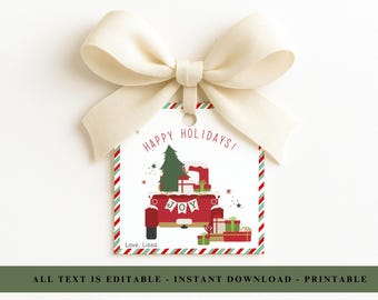 Puede incluir: Una etiqueta de regalo navideña con un camión rojo que transporta un árbol de Navidad y regalos. La etiqueta tiene un fondo blanco con bordes a rayas rojas y verdes y un lazo color crema. El texto dice "Happy Holidays!" y "Joy".