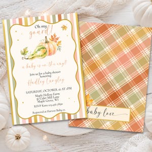 May include: A rectangular baby shower invitation featuring a watercolor pumpkin illustration and the text Oh my gourd! a baby is on the way! with event details for Hadley Langley. The reverse side displays a plaid pattern in orange, green, and cream.