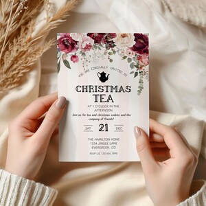 May include: A Christmas tea party invitation with a floral design. The invitation features a teapot icon and the text "Christmas Tea" in black lettering. The invitation is for Saturday, December 21st at 1 o'clock in the afternoon. The Hamilton Home is located at 1234 Jingle Lane, Evergreen, CO. RSVP to Liz at 123.456.7890.
