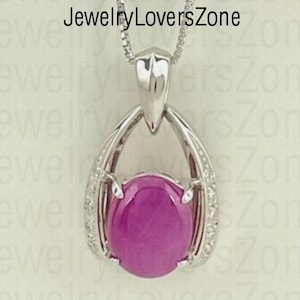 May include: A silver pendant necklace with a pink gemstone surrounded by small diamonds. The pendant is shaped like a teardrop with a delicate design.