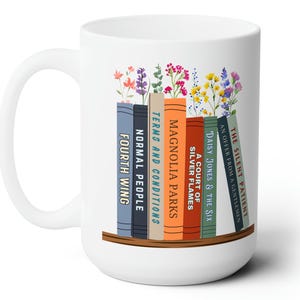 White 15 oz mug with seven books on a shelf with wildflowers for bookmarks. Book titles can be customized to a person's favorite books.