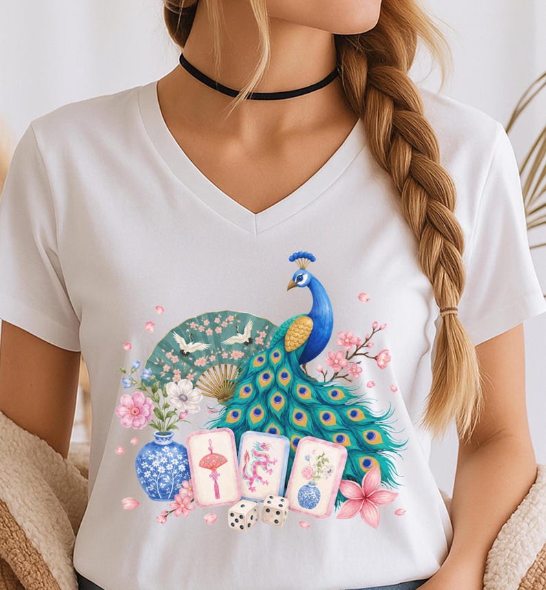 May include: A white V-neck t-shirt featuring a colorful graphic print of a peacock with vibrant blue and green feathers, a folding fan with crane illustrations, a blue and white vase, three mahjong tiles, two dice, and pink floral accents.