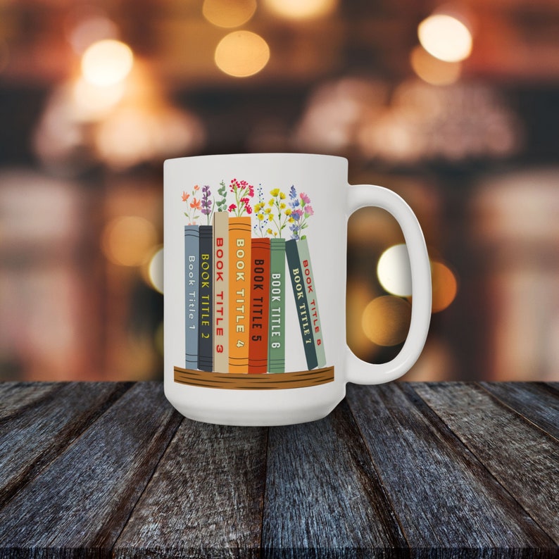 White 15 oz mug with seven books on a shelf with wildflowers for bookmarks. Book titles can be customized to a person's favorite books.