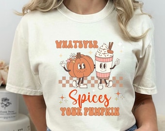 May include: A white t-shirt featuring a graphic of a pumpkin and a cup of coffee. The text on the shirt reads "Whatever Spices Your Pumpkin".