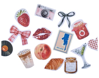May include: A collection of watercolor stickers featuring a variety of objects. Includes a strawberry, camera, bow, lips, New York postcard, jam jar, martini, vinyl record, coffee drink, peach, croissant, and a pine tree candle.