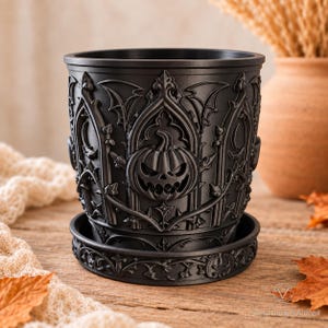 Matte black Gothic Pumpkin dry planter with matching saucer on a warm autumn tabletop.