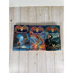 May include: Three Shadowrun paperback books titled Never Trust an Elf, Into the Shadows, and Choose Your Enemies Carefully. Each cover features a ram skull logo, fantasy illustrations of characters and creatures, and the author's name in bold text.