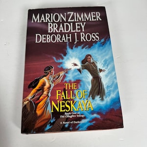 May include: A paperback book titled "The Fall of Neskaya" by Marion Zimmer Bradley and Deborah J. Ross. The cover depicts two figures with glowing hands against a backdrop of blue energy and a dark red sky. The book is part of "The Clingfire Trilogy."