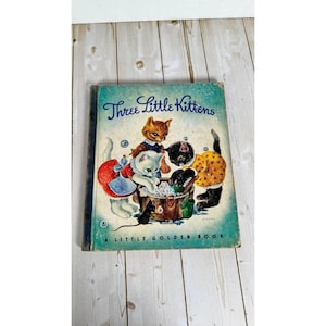 May include: Vintage children's book titled "Three Little Kittens" with a teal cover. The cover illustration depicts three kittens washing in a tub, with a fourth kitten watching. The book is part of the "A Little Golden Book" series.