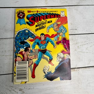 Può includere: Un fumetto vintage di Superman con sfondo giallo. La copertina presenta Superman in un costume blu e rosso, circondato da altri personaggi. Il testo include "Superman" e "Battaglie contro gli uomini più potenti dell'universo!"