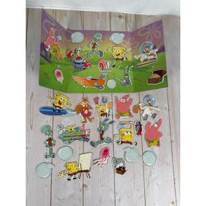 Op de afbeelding: Een SpongeBob SquarePants speelset met een drievoudige achtergrond en karakteruitsparingen. De set bevat SpongeBob, Patrick, Octo Tentakel en andere personages. De set staat op een licht houten oppervlak.