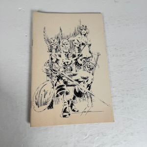 May include: A vintage comic book cover featuring a black and white illustration of a muscular man seated on a throne, holding a sword. A woman and another man with a sword are behind him. The cover is on a cream-colored background.